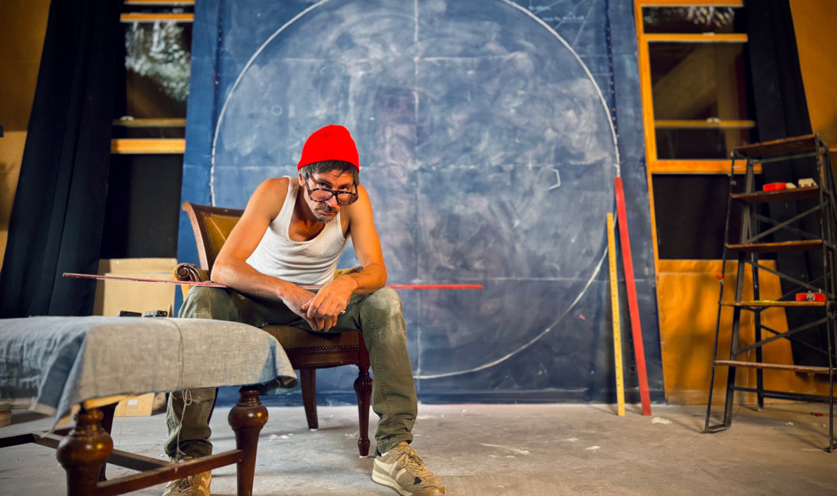 Tommy Hoppe in front of the studio chalkboard